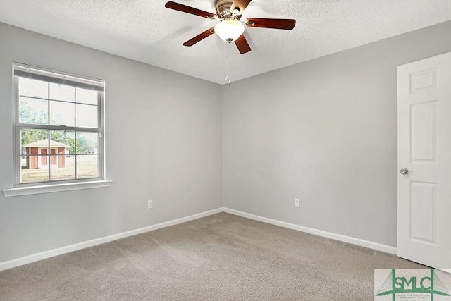 carpeted spare room with ceiling fan and a textured ceiling