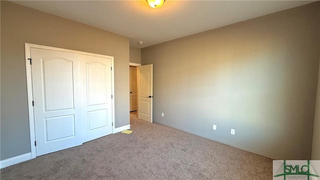 unfurnished bedroom with light carpet and a closet