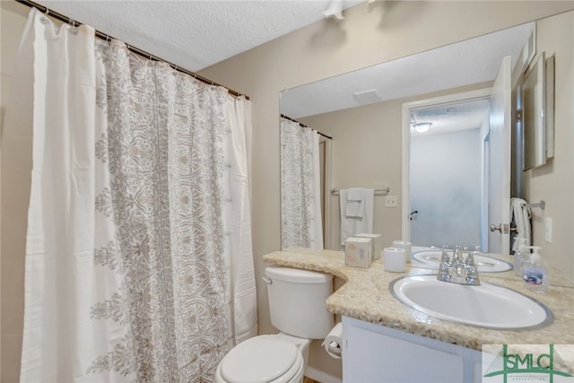 bathroom with toilet, vanity, and a textured ceiling