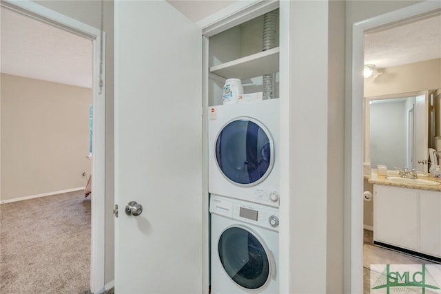 washroom featuring sink, a textured ceiling, stacked washer and clothes dryer, and light carpet