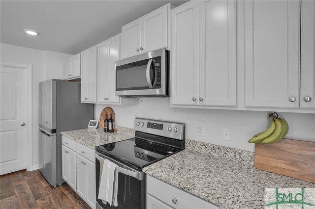 kitchen featuring appliances with stainless steel finishes, white cabinets, and light stone counters