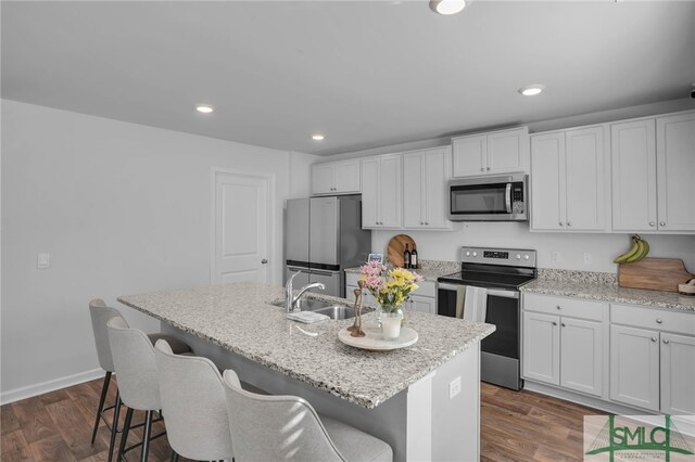 kitchen featuring appliances with stainless steel finishes, sink, white cabinets, and an island with sink