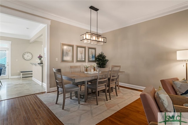 dining room featuring light hardwood / wood-style flooring, crown molding, and a chandelier