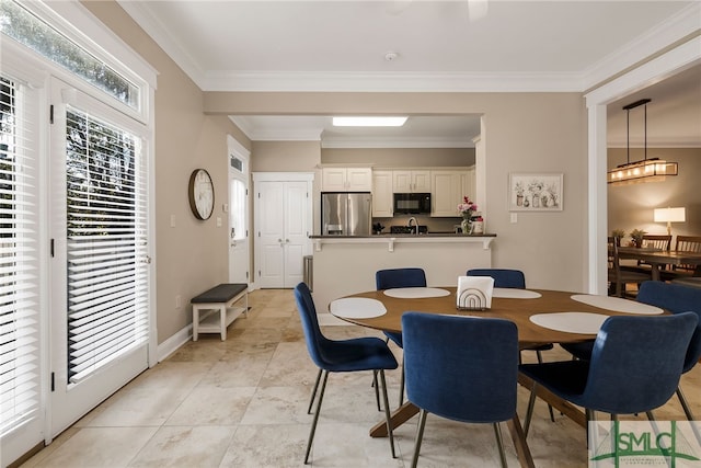 tiled dining room featuring ornamental molding and a healthy amount of sunlight