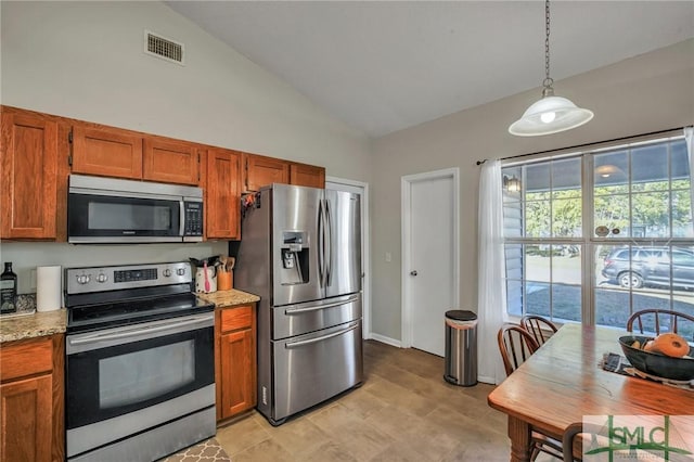 kitchen with light stone countertops, hanging light fixtures, appliances with stainless steel finishes, and vaulted ceiling