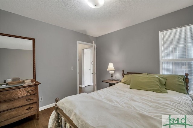 bedroom featuring dark hardwood / wood-style floors and a textured ceiling