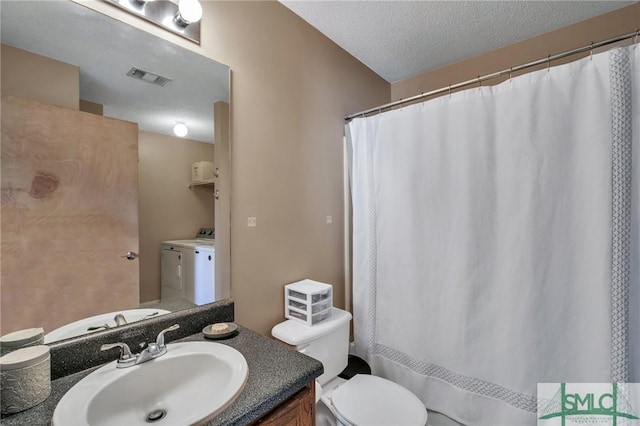 bathroom with toilet, vanity, independent washer and dryer, and a textured ceiling