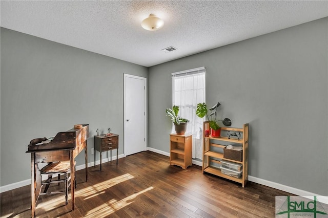 miscellaneous room with a textured ceiling and dark hardwood / wood-style flooring