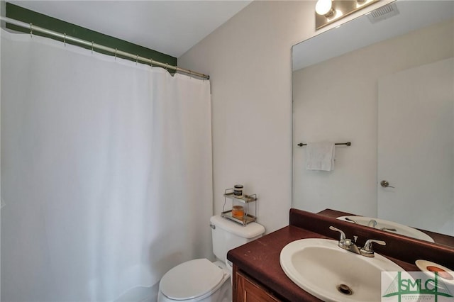 bathroom featuring toilet, vanity, and walk in shower