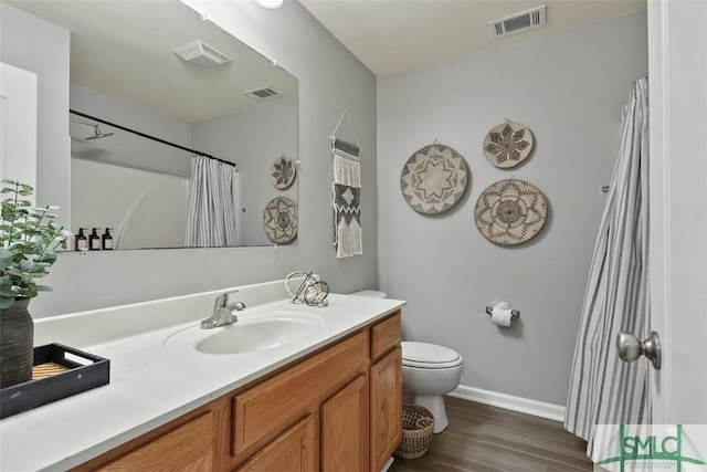 bathroom with toilet, vanity, curtained shower, and hardwood / wood-style floors