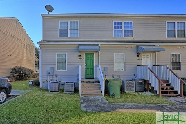 view of front of property with a front yard and central AC unit