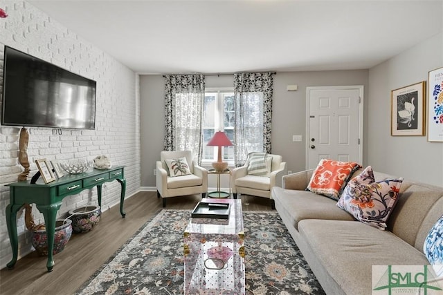 living room with wood-type flooring and brick wall