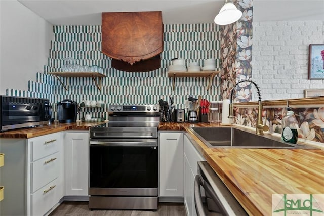 kitchen featuring dishwasher, white cabinets, butcher block countertops, and electric stove