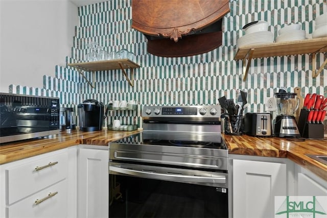 kitchen featuring tasteful backsplash, appliances with stainless steel finishes, butcher block counters, and white cabinetry