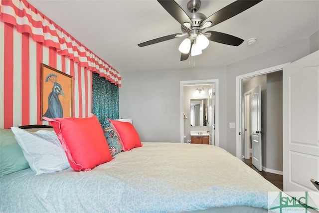 bedroom with ceiling fan, dark wood-type flooring, and connected bathroom