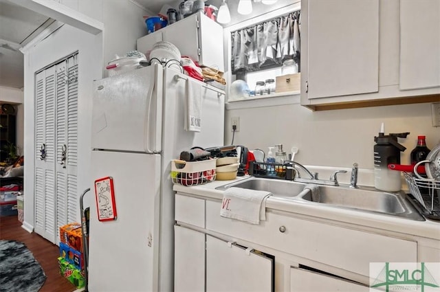 kitchen with dark hardwood / wood-style floors, sink, white refrigerator, and white cabinetry