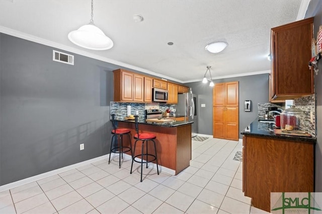 kitchen featuring crown molding, appliances with stainless steel finishes, decorative backsplash, and decorative light fixtures