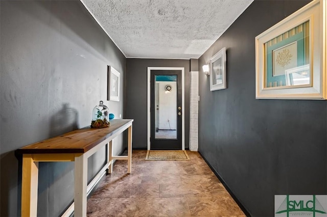 doorway to outside featuring a textured ceiling