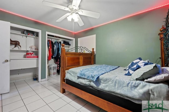 tiled bedroom with ceiling fan and a closet