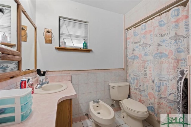 bathroom with tile patterned flooring, vanity, tile walls, toilet, and a bidet