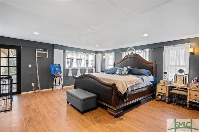 bedroom featuring a wall mounted AC and hardwood / wood-style floors