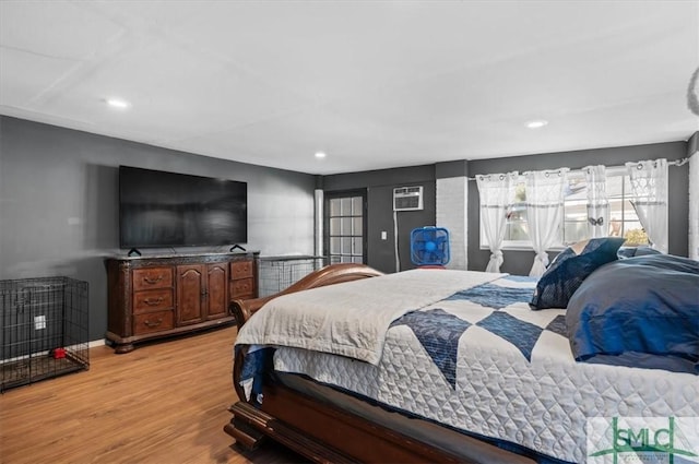 bedroom featuring light hardwood / wood-style floors and a wall mounted AC