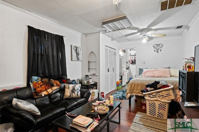 bedroom with ceiling fan, a closet, dark wood-type flooring, and a textured ceiling