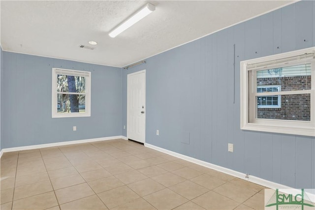 empty room featuring light tile patterned floors and a textured ceiling