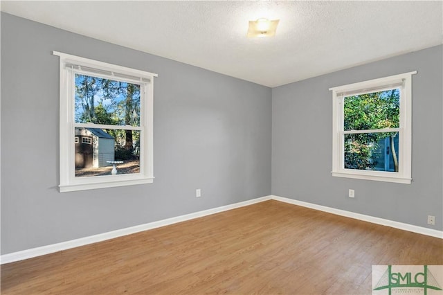 spare room with a textured ceiling and hardwood / wood-style flooring