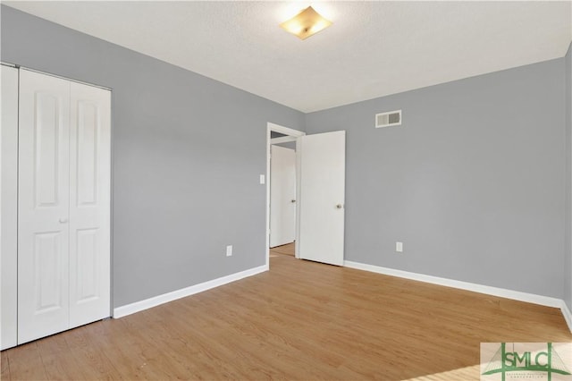 unfurnished bedroom featuring a closet and light hardwood / wood-style floors