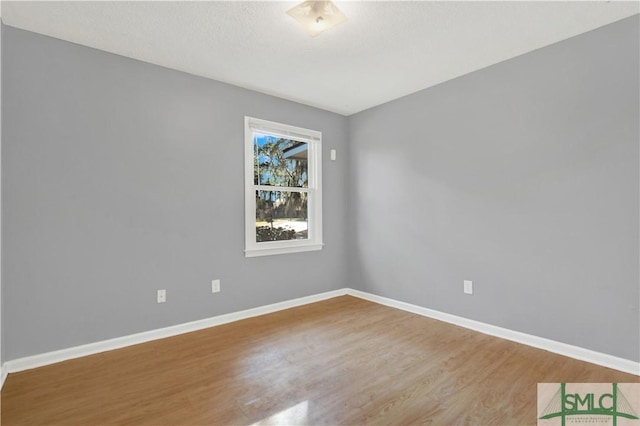 empty room with wood-type flooring and a textured ceiling