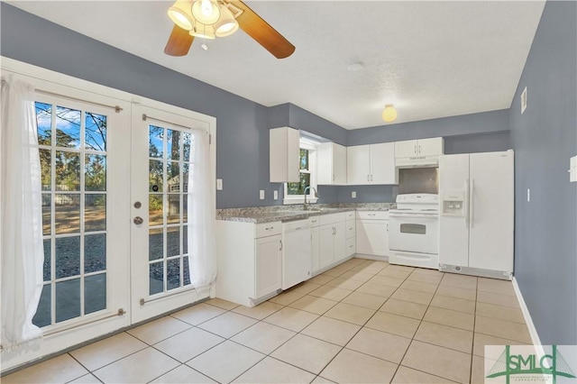 kitchen with white appliances, light tile patterned flooring, french doors, white cabinets, and sink