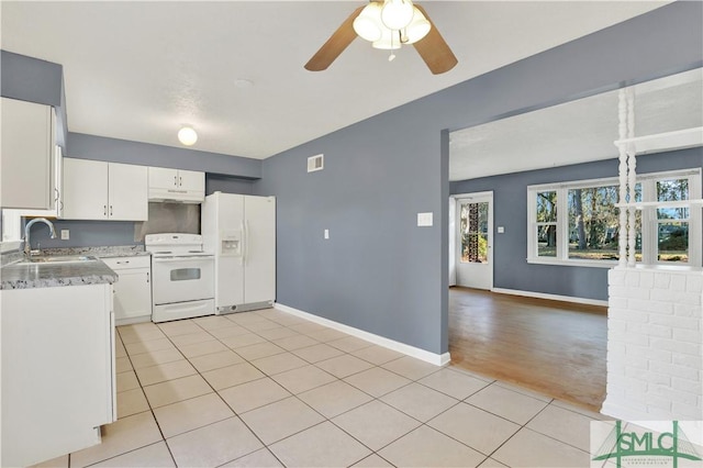 kitchen with light tile patterned flooring, white cabinetry, sink, and white appliances