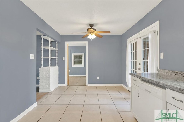 unfurnished dining area with light tile patterned floors, french doors, and ceiling fan