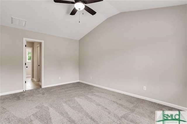 carpeted spare room featuring a ceiling fan, visible vents, vaulted ceiling, and baseboards