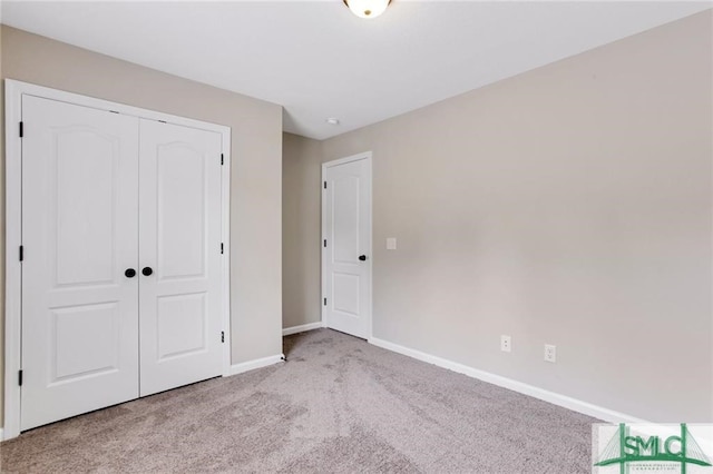 unfurnished bedroom featuring light carpet and a closet