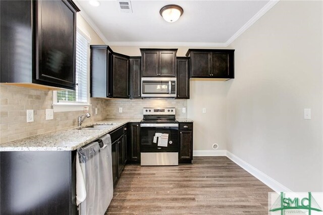 kitchen featuring light hardwood / wood-style floors, sink, crown molding, stainless steel appliances, and light stone counters