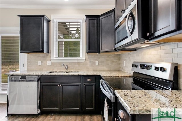 kitchen with tasteful backsplash, ornamental molding, dark wood-type flooring, stainless steel appliances, and a sink