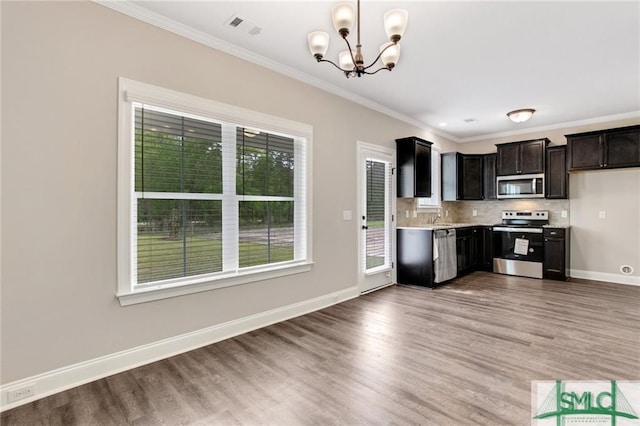 kitchen with tasteful backsplash, light countertops, visible vents, appliances with stainless steel finishes, and baseboards