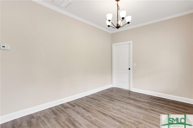 unfurnished room with a chandelier, ornamental molding, wood finished floors, and baseboards