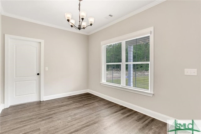 empty room featuring a notable chandelier, ornamental molding, and hardwood / wood-style floors