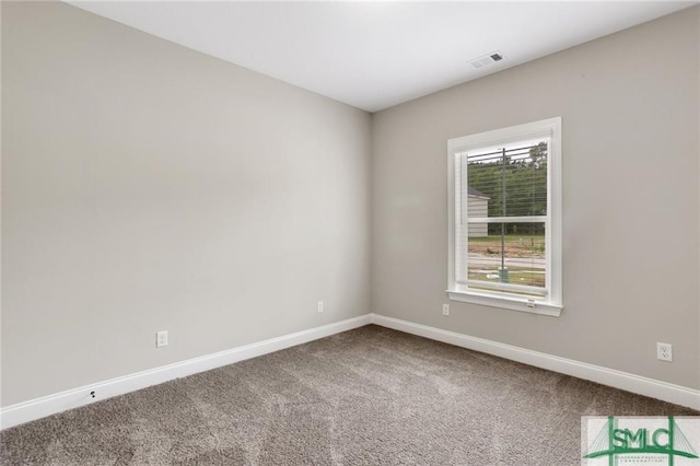 empty room featuring carpet floors, visible vents, and baseboards