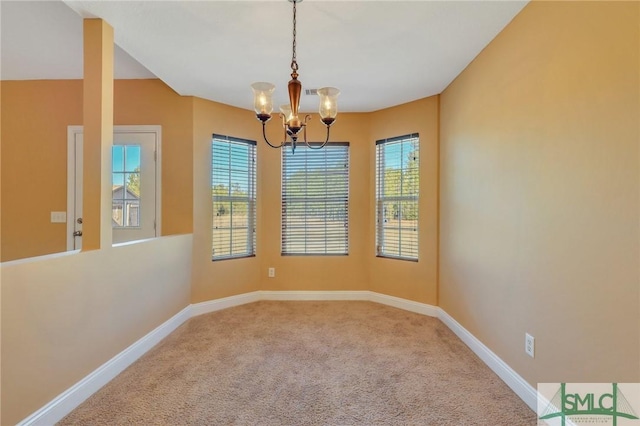 carpeted spare room with a chandelier and a healthy amount of sunlight