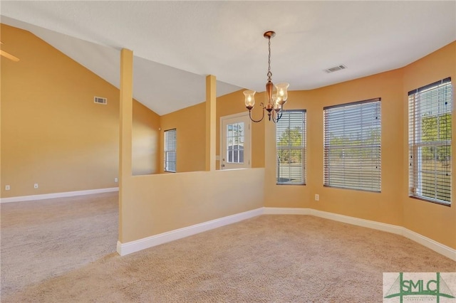 carpeted empty room featuring a chandelier and vaulted ceiling