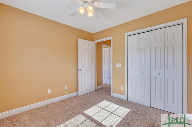 unfurnished bedroom with ceiling fan, a closet, and light carpet