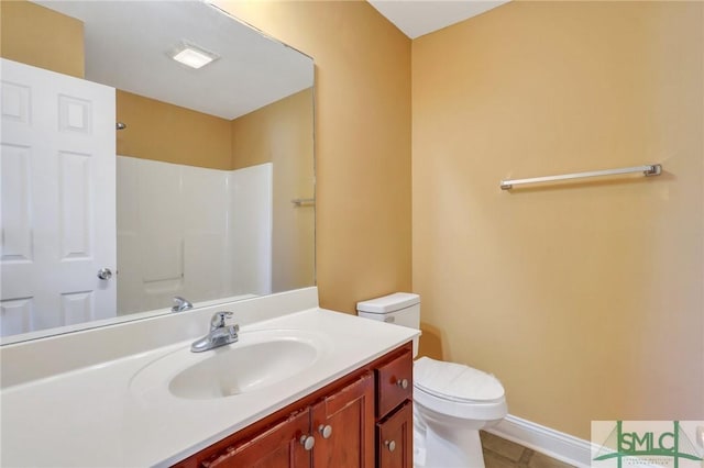 bathroom with toilet, vanity, and walk in shower