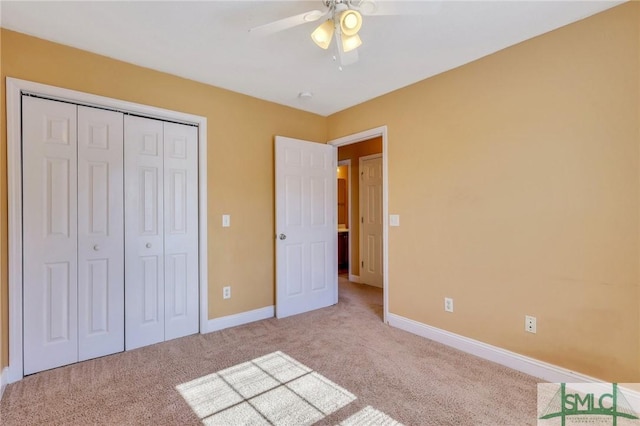 unfurnished bedroom with ceiling fan, a closet, and light carpet