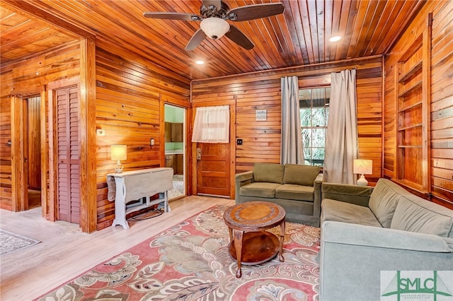 living room featuring wooden ceiling, light hardwood / wood-style floors, wooden walls, and ceiling fan