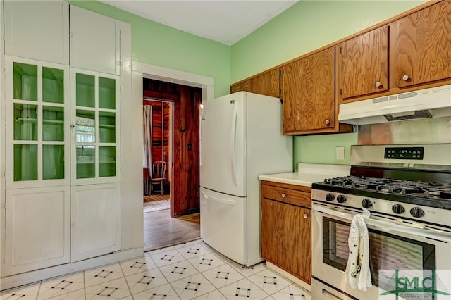 kitchen with stainless steel gas range and white refrigerator