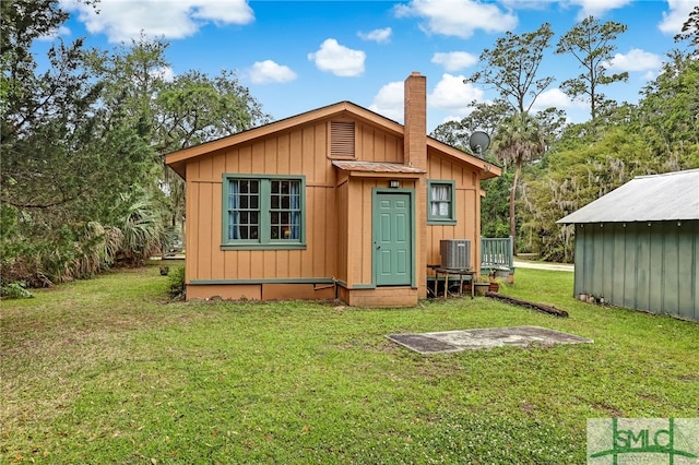 view of outbuilding with a lawn and cooling unit